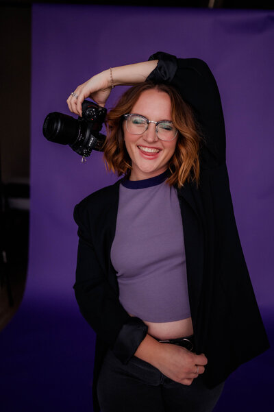 Woman poses for the camera with Nikon Z6II Camera in hand.