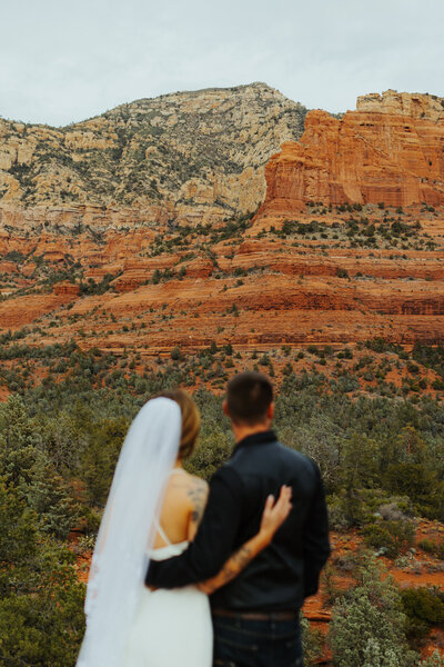 bride and groom admire the sedona landscape on their wedding day