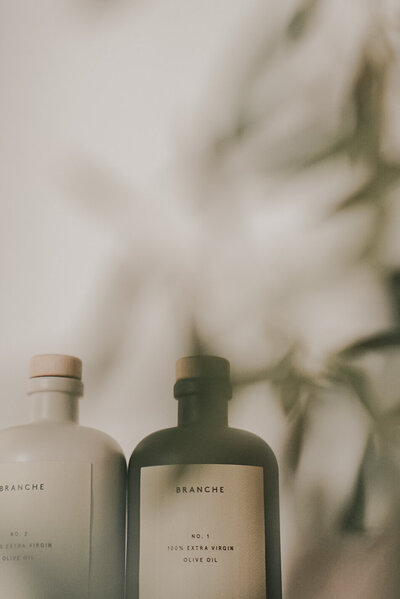 Two minimalist wellness care product bottles with soft natural light, reflecting intentional self-care, ritual, and elevated clean beauty design.