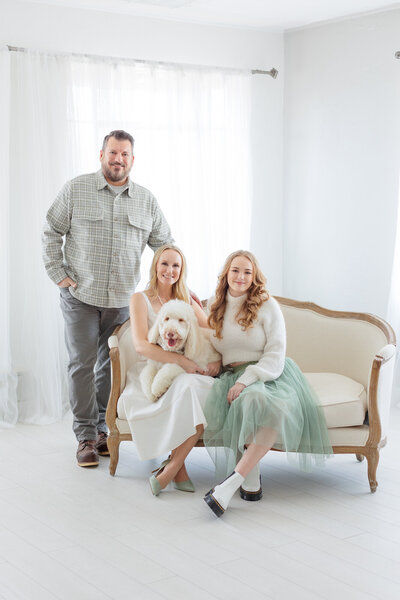 Boise family in Tiffany Hix Photography studio in Boise sitting on a sofa with their dog