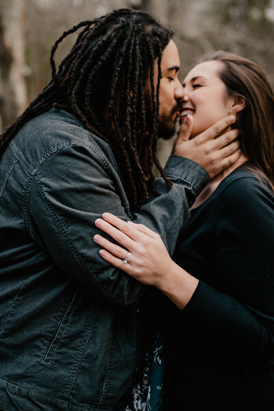 couple almost kissing in the woods