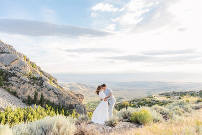Bride and groom sharing a romantic kiss on their wedding day at Five Springs Campground in Lovell, Wyoming, with breathtaking mountain views as their backdrop.