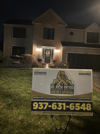 Black Bear Roofing & Exteriors yard sign advertising services and contact information.