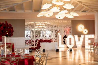A red and white wedding reception with a large love sign.