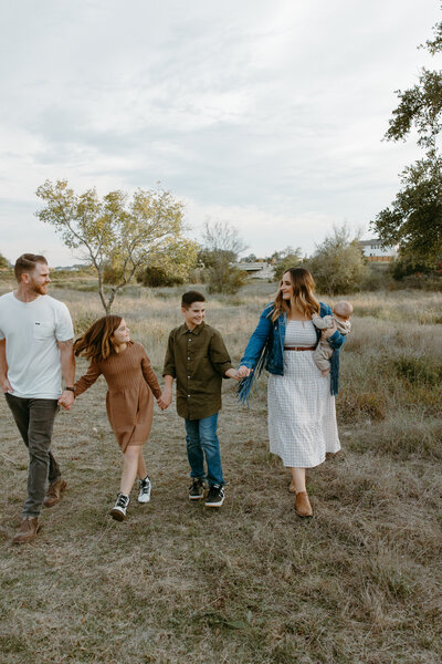 Austin Wedding Photographers Jessie and Dylan Schultz posing with their family  in a field