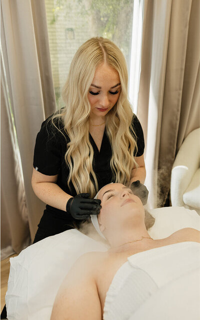 A nurse gives a patient a relaxing facial. She is using hot steam to open up the pores.