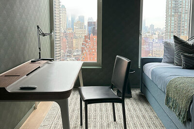 Boston interior decorators design a colorful Upper East Side bedroom with green and blue patterns, city views, and a vibrant modern apartment style.