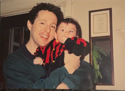 A dad holding a small boy and smiling