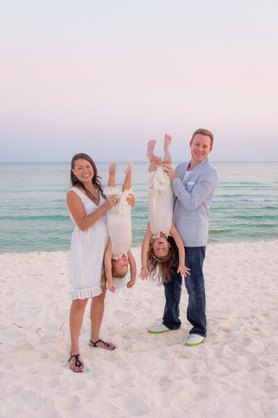 mom-and-dad-holiding-kids-upside-down-on-pensacola-beach