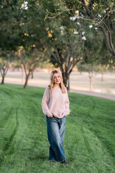 senior girl posing for senior photos on grass in gilbert az