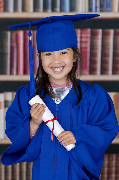 Preschool girl wearing a beautiful colouful dress with matching headband is smiling for her school photo