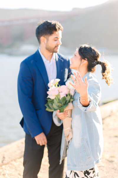 Engagement couple with girl holding flower bouquet and showing her engagement ring hand, engagement in Sausalito, photo by Anastasiya Photography - San Francisco Photographer