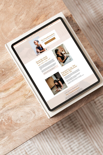 A tablet displaying an online magazine page with images and text is placed on a wooden surface. The layout, designed by a web designer for small businesses, includes articles and photographs in a clean, minimalist design.