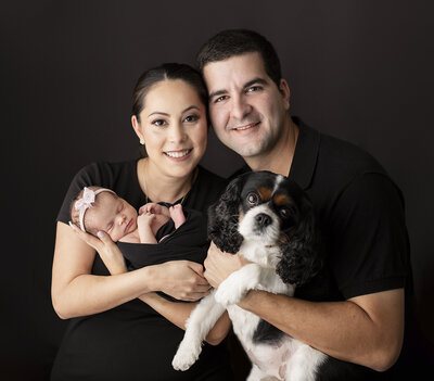 newborn family photo smiling with dad holding dog