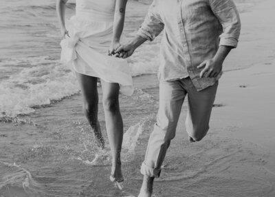 couple running through the waves