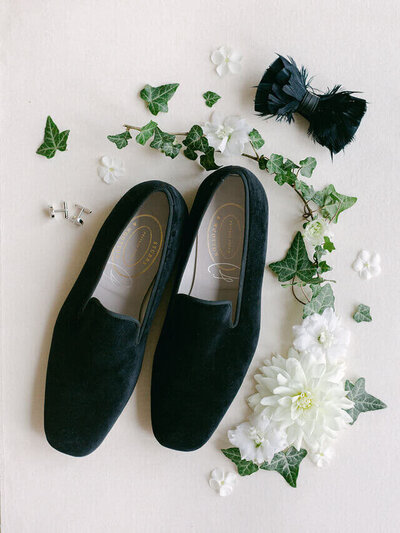 Mens wedding shoes surrounded by white flowers