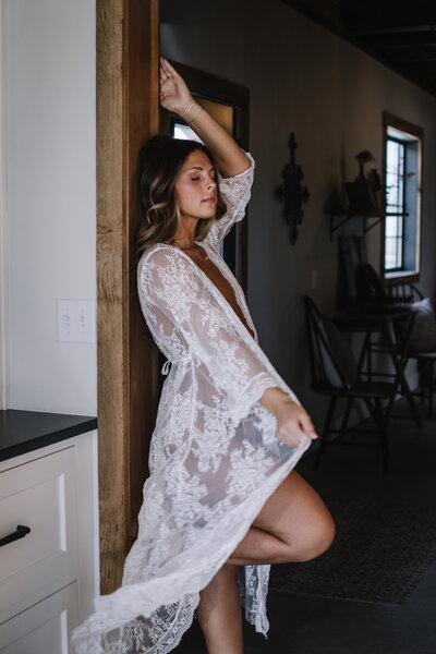 A women posed on beam in a white flowing  top