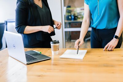 Two women at a desk with a laptop, engaged in professional supervision and case consultation in Littleton, Colorado.
