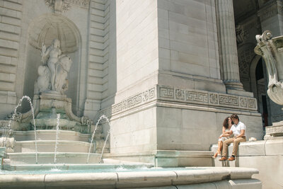 Detail of a monumental stone fountain showing rusticated stonework, tiered basins, and a central sculptural figure within an archway.