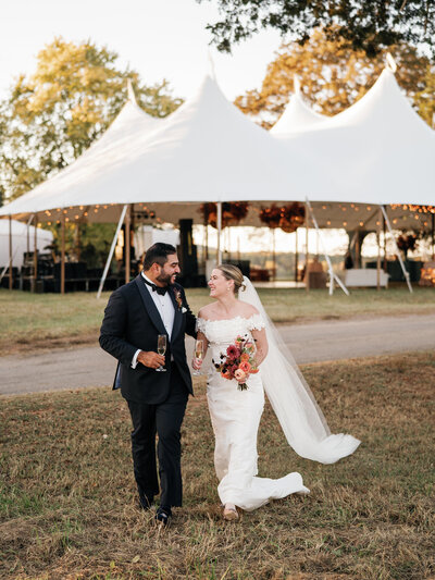 A couple in front of their sailcloth tent on their wedding day