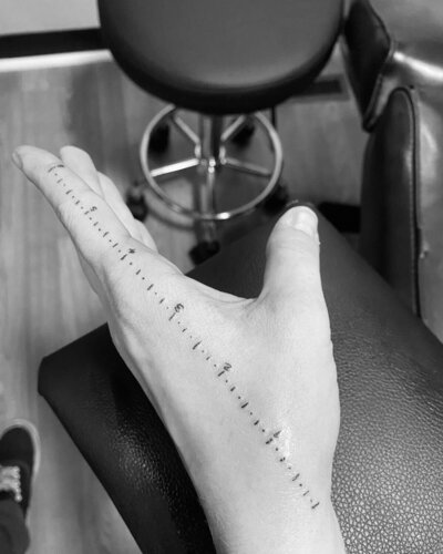 Black and white photo of a hand with a tattoo