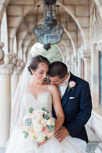 Wedding photo at Disney of groom kissing brides shoulder