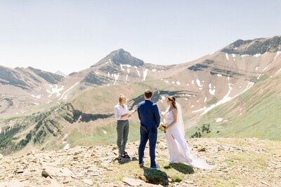 This beautiful photograph captures the bride and groom saying their vows to each other during their wedding ceremony at Mount Charles Stewart. Set against the stunning backdrop of a perfect summer day, the intimate moment reflects the love and commitment shared on their special day.