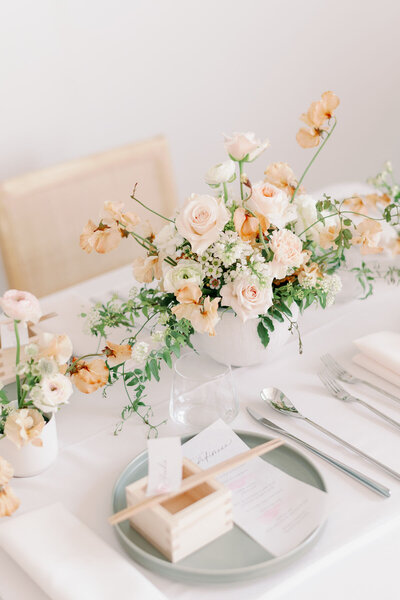 Elegant Japanese wedding table setting with peach florals and a masu sake cup — perfect for kimono wedding rental in Los Angeles, California | ロサンゼルス（カリフォルニア）の着物ウェディングレンタルに最適な、ピーチカラーの装花と枡が映える上品な和のテーブルコーディネート