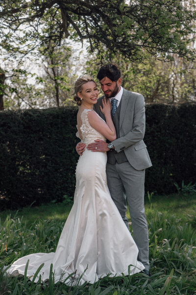 Wedding photographer captures a couple embracing outside the manor houses grounds in oxfordshire