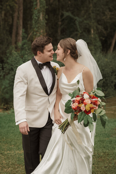 couple smiling walking together tropical greenery wedding day