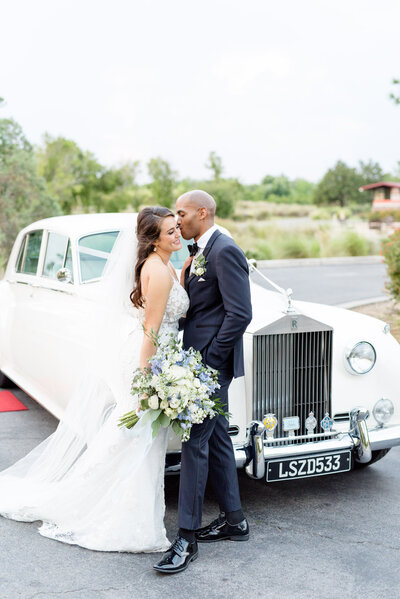 Groom and bride next to classic car taken by wedding photographers in Auburn, Al.