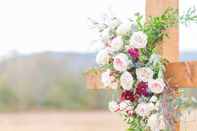 Wooden cross adorned with floral arrangement for wedding ceremony  | Alabama wedding photographer Amanda Horne