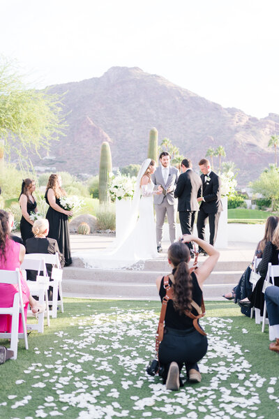 Phoenix wedding photographer, Kaylie Miller holding her camera smiling at the Salt Flats.