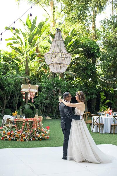 Bride and Groom dancing on their wedding day while Bride holds a glass of wine in California