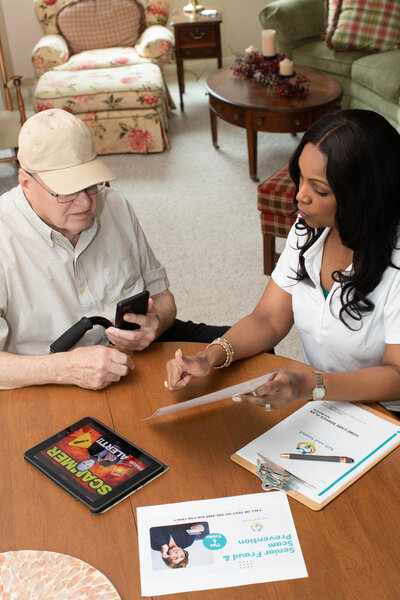 Senior man learning to use a tablet with help from caregiver and Tracy Morris