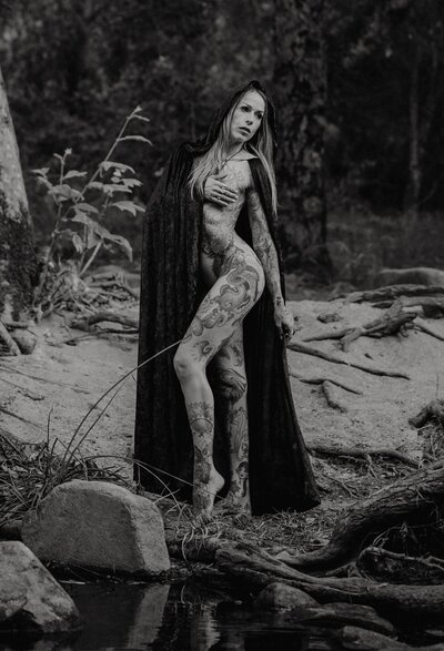 a girl is is half naked near a river near san diego california is cosplaying as a witch for her portrait photographer