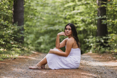 Girl sitting on ground with arm on leg | Maine Senior Session