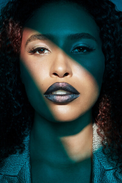 Moody portrait of Jazz Walters with dramatic lighting and bold makeup, captured by Ylva Erevall in a high-contrast, artistic studio setting.