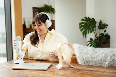 Chantal Hewitt wearing white headphones and smiling in a yellow shirt while recording an episode of The Attuned Spectrum Podcast  - Family Autism Support Coach at Chantal Hewitt Coaching14
