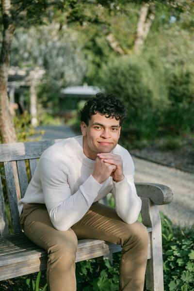 high school senior guy at pnw river park leaning against tree