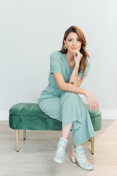 the owner of Amarena Productions sitting o a sofa, looking at the camera