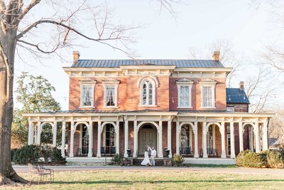 photo of couple in front of a beautiful mansion at their engagement session in Murfreesboro, Tennessee