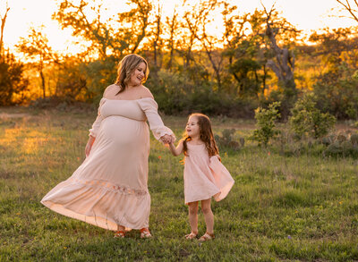 pregnant mother dancing with young daughter