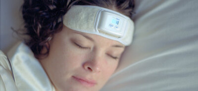 Person sleeping with a biofeedback headband, used to manage nighttime teeth grinding (bruxism) associated with TMJ.