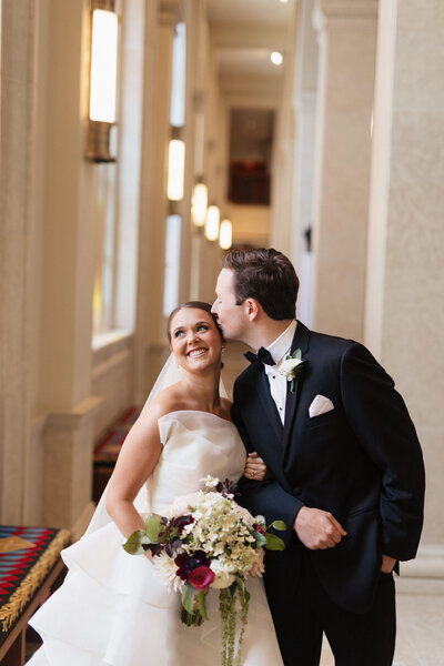 Wedding party cheers as the bride and groom share a kiss, surrounded by laughter and joy.