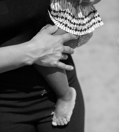 Woman sitting, gently hugging her shoulder