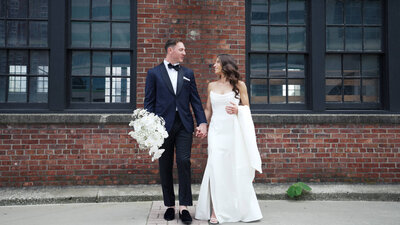 Bride and groom holding hands outside wedding venue in Battello, New Jersey