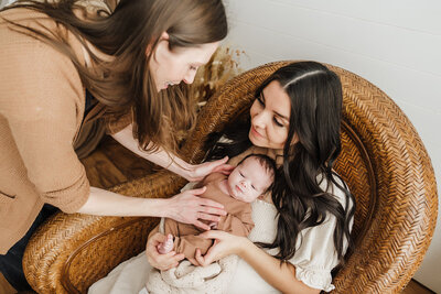 photographer adjusts mother and newborn during photoshoot