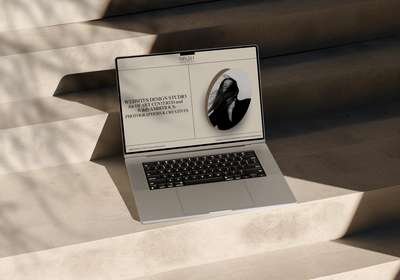 Laptop open on stairs with a shadow casting over it