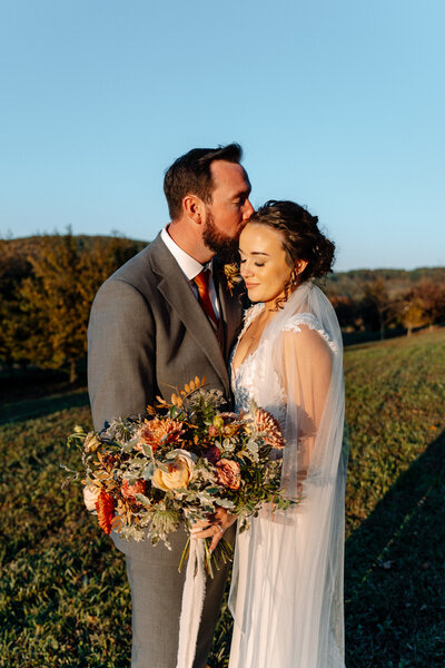 couple embracing in field at a vineyard